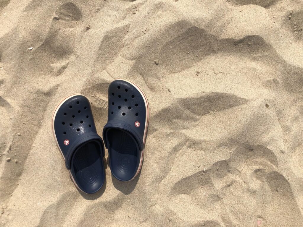 Námornícky modré topánky Crocs na pláži