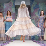 Trendy 2024 módne šaty na jar 2024 - v popredí modelka v širokých, vzdušných šatách s kvetinovým motívom ​