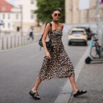 cez ulicu prechádza mladá žena v ľahkých vzdušných šatách s leopardím vzorom