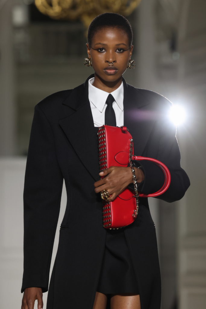 modelka na móle s červenou taškou s cvočkami