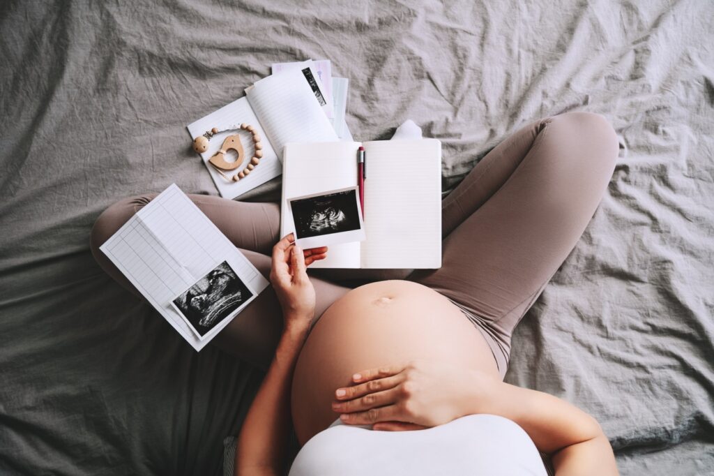 tehotná žena si prezerá fotografie z ultrazvuku